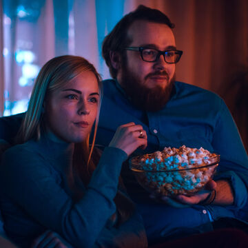 Couple in home theatre eating popcorn